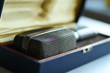 Obraz premium Close-up of a professional quality microphone in a carrying case, placed on a desk.
