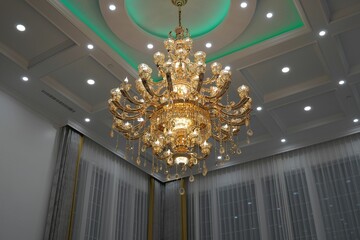 Beautiful shiny golden chandelier hanging from the ceiling.