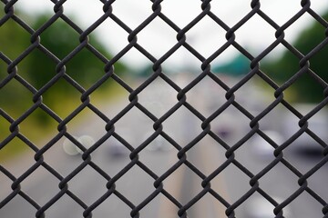 Close-up view of a silver wire fence creates a patterned background