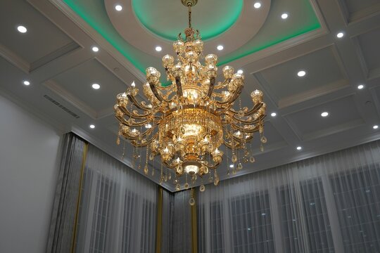 Beautiful shiny golden chandelier hanging from the ceiling.