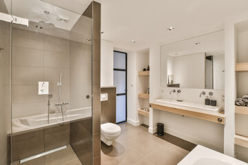 a modern bathroom with toilet, sink and bathtub in the middle part of the room there is a mirror on...