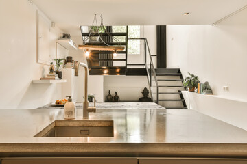 a kitchen and stairs in a tiny apartment with an open staircase leading up to the second floor, as...