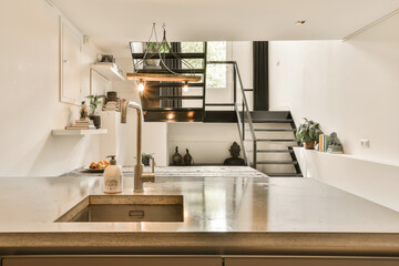 a kitchen and stairs in a tiny apartment with an open staircase leading up to the second floor, as well as possible