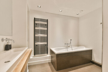 a bathroom with a bathtub, sink and towel rack in the middle of the room on the right side