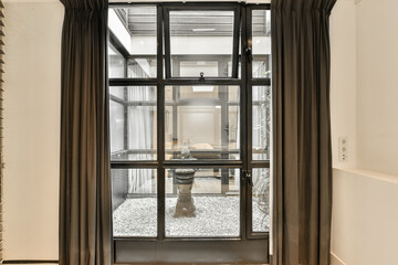 a bathroom with a toilet in the middle and a window to the right that looks out into an outside area