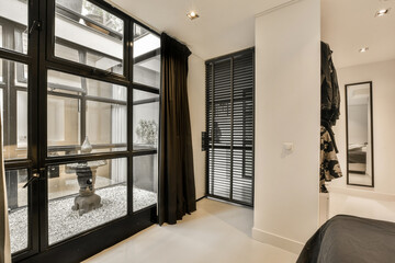 a bedroom with black shutters and an aquarium in the window, as seen from the other room's