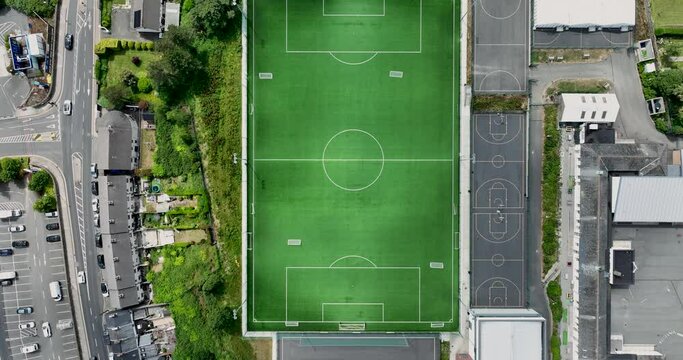 Aerial view of a green empty football field in the middle of the city 4k