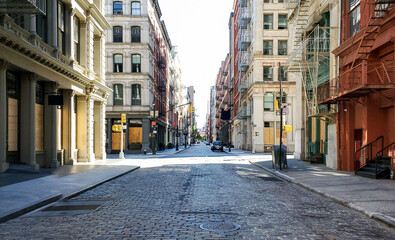 Empty streets and sidewalks of Soho are eerily quiet during the 2020 coronavirus pandemic lockdown in New York City with no people and sunset background - 637123860