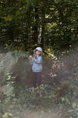 Adorable little girl hiking in the forest, spending time in the nature, outdoors experience in the countryside