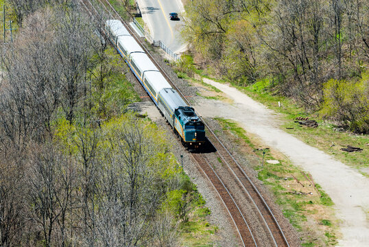 HAMILTON, ONTARIO, CANADA - MAY 11, 2014 - A short VIA Rail passenger train passes through a wooded area. VIA Rail operates Canada's national passenger rail service.