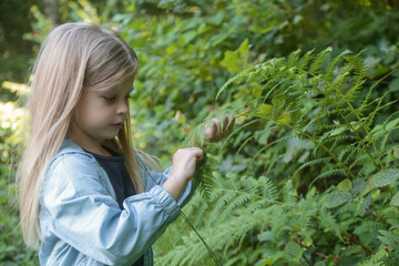 Cute little girl exploring nature. Child playing outdoors. 