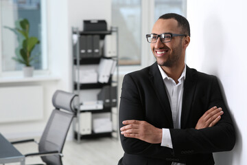 Fototapeta na wymiar Smiling young businessman in office. Space for text