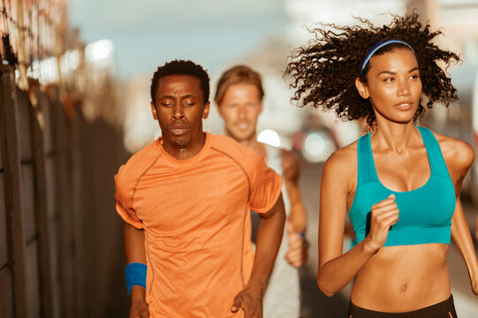 Diverse group of young people sprinting and running together in the city