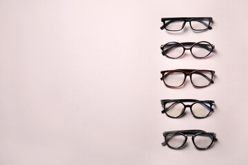 Many different stylish glasses on light grey background, flat lay. Space for text