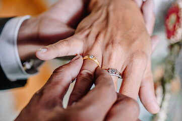 the groom puts a wedding ring on the bride's ring finger as a sign that they are officially married...