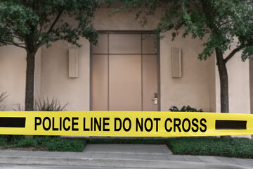 Fototapeta premium Yellow crime scene tape blocking way to house outdoors