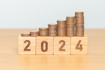 2024 year block with Coins stack. Money, Budget, tax, investment, financial, savings and New Year...