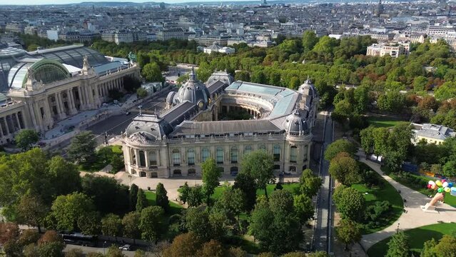 Petit Palais and Grand Palais in Paris with La Defense financial district in background, France. Aerial drone circling view