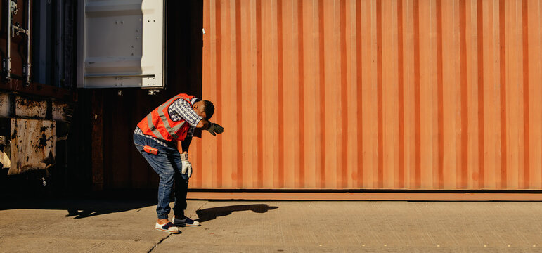 African American male workers suffer dehydration heatstroke thirst dizziness headache nausea rapid breathing vomiting unbearable dizziness in the hot weather in the container yard.