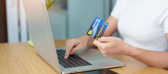woman hand holding credit card and using laptop with mobile phone for online shopping while making order. Marketplace platform website, technology, ecommerce, digital banking and online payment