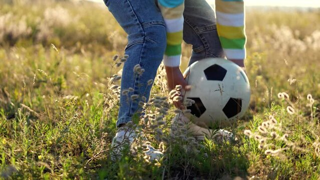 girl boy playing game football park. kick ball with their feet grassy field. summer day park outdoor space families can enjoy themselves. daughter son, kid happily running around, enjoying game