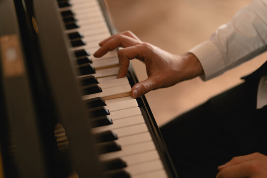 The keyboard of a very old abandoned piano is covered with dust, some keys have dropped, some are absent.