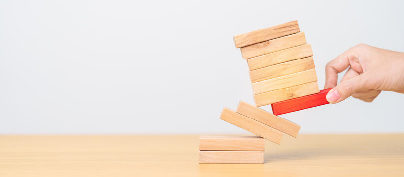 woman hand pulling wood domino blocks on table. Crisis, fall Business, Risk management, Economic recession, Strategy and solutions concept