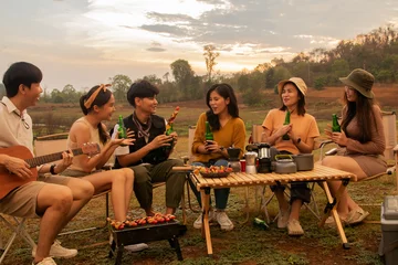 Foto op Aluminium Camping in the evening, sunset behind the mountain with beautiful nature : Young asian gangs of young men and women chatting singing and drinking cold beers happily during an holiday overnight trip. © ฺฺฺBoonterm