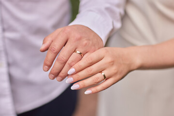 The groom is putting the wedding ring on the bride s finger. Close-up view of the hands. - Powered by Adobe