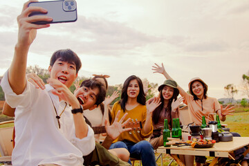 Group of best friends men and women hilarious party together taking selfies on the table camping...