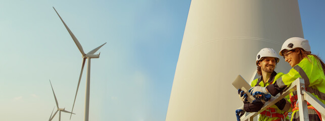 Technician working outdoors, wind farm professional team male and female safety uniform ready to...