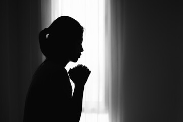 silhouette of Religious young woman praying to God in the morning, spirtuality and religion,...