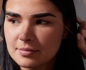 Beautiful young girl got correction of eyebrows in a beauty salon.