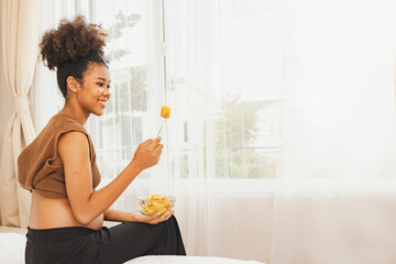 Young mother of Thai-African descent eats steamed pumpkin health healthy diet that contains...