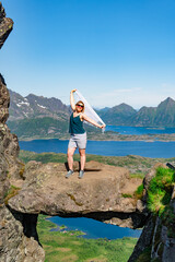 Brave traveler woman standing on hanging stone between rocks. Djevelporten in Norway Lofoten islands. Adventure, hiking, traveling, active lifestyle, vacation healthy lifestyle hiking in Scandinavia