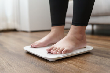 Fototapeta premium Fat diet and scale feet standing on electronic scales for weight control. Measurement instrument in kilogram for a diet control.