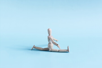 The figure of a wooden one does the splits in close-up. physical exercises and gymnastics.