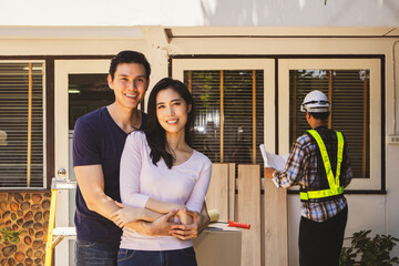 Asian couple embracing happy outside their house with renovated housing old second hand house...