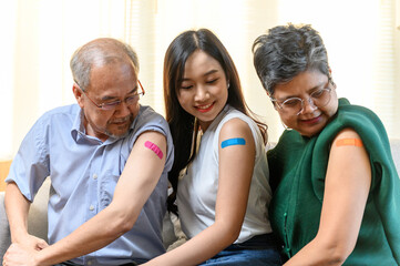 Group of diverse age Asian people family senior showing bandage plaster on arm after received covid vaccination for prevent covid-19 infection. Coronavirus pandemic protection health care concept.