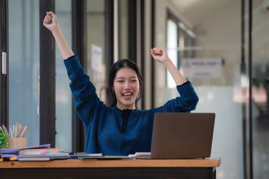 Young Asian women celebrate success or happy poses with a laptop.