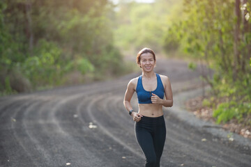 young fitness woman runner athlete running at road. athlete woman in running start pose on countryside street. sport tight clothes. bright sunset,  Healthy woman on morning road workout jogging.