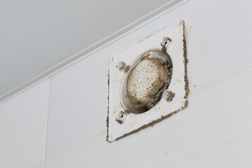 A man wipes dust from a ventilation grill technician cleaning air.