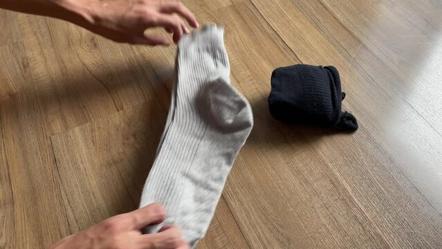 Male hands rolling socks. Folding cloth for travel concept