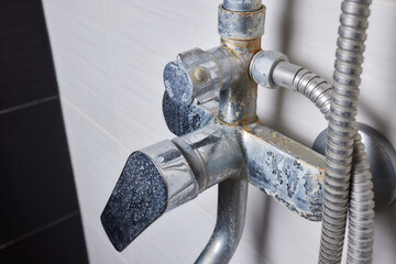 A thin stream of hard water flows from an old tap aerator. Old Bathroom Sink Faucet contaminated...