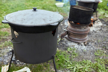 Hiking pot, Bowler in the bonfire. in cauldron at the stake. Traveling, tourism, picnic cooking,...