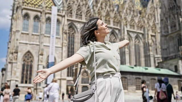 Young beautiful hispanic woman with open arms at St. Stephen's Cathedral