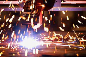 Bright flame sparks fly during plasma cutting out of details