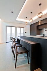 The island table and the chairs next to each other create a bar-like feel