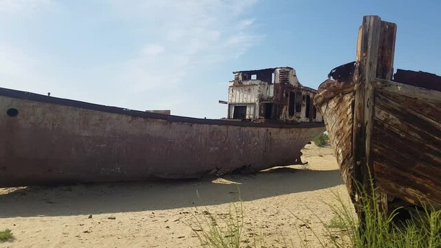 Abandoned Ship and Wooden Boat in Decay in Sand of Former Aral Lake, Natural Disaster Site in Uzbekistan and Kazachstan