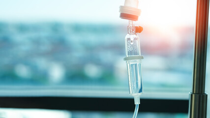 Close up saline solution drip for patient and infusion pump in hospital, with space and bright background. - obrazy, fototapety, plakaty